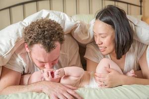 Mixed Race Chinese and Caucasian Baby Boy Laying In Bed with His Parents photo