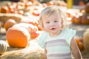 adorable niña divirtiéndose en el huerto de calabazas foto