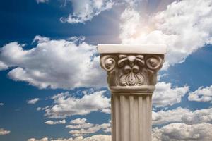 pilar de columna de réplica antigua sobre nubes y sol foto