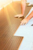 Man Installing New Laminate Wood Flooring photo