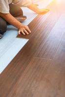 Man Installing New Laminate Wood Flooring photo