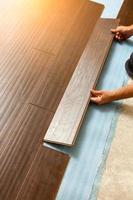 Man Installing New Laminate Wood Flooring photo