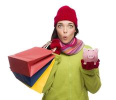 Concerned Expressive Mixed Race Woman Holding Shopping Bags and Piggybank photo