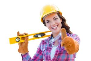 Female Construction Worker with Thumbs Up Holding Level Wearing Gloves, Hard Hat and Protective Goggles On White photo