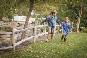 Happy Young Brother and Sister Running Outside photo