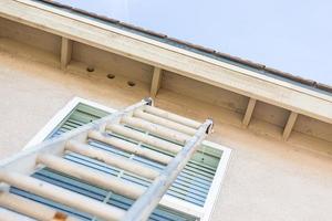 Construction Ladder Leaning Against House photo