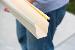 Worker Measuring Rain Gutter Processing Through Seamless Shaping Machine photo