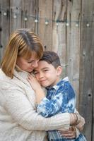 Mother and Mixed Race Son Hug Near Fence photo