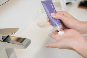 Close up of women applying body lotion cream on hand. photo