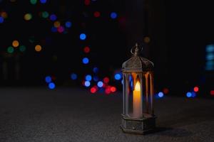Islamic Lantern lighting up with blurry bokeh light background.Eid decorative traditional Arabic lamps illuminated ready for the Holy season of Ramadan Kareem.Islamic muslim holidays celebrate concept photo