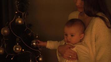 weinig baby meisje met haar moeder Bij Kerstmis boom video