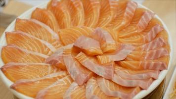 Vidéo 4k de l'assiette pleine de sashimi de saumon, nourriture de style japonais au poisson cru. video
