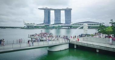 vista de timelapse da área da baía da marina de singapura com arranha-céus arranha-céus e estátua de merlion famoso marco de singapura com muitos turistas video