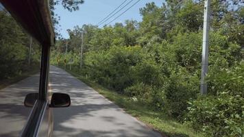 Visualizza per davanti di il pubblico mezzi di trasporto auto mentre guida su il Locale strada attraverso il montagna collina tra albero foresta video