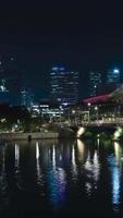 vista vertical de lapso de tempo da área da baía de marina de singapura com arranha-céus e tráfego na rua, famoso marco de singapura durante a noite video