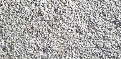 Small white and gray or grey gravel, rock or stone on the floor for background. Hard material, Art or natural wallpaper and Group of object concept photo