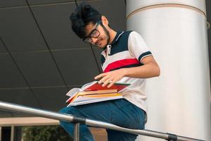 young guy with black hair looks in the books photo