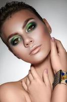 young beautiful girl with beautiful makeup in green colors  and a short haircut photo