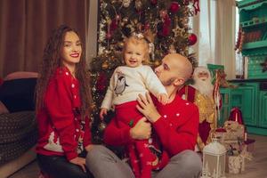 horizontal photo of young family with daughter celebrate New year and Christmas together at home