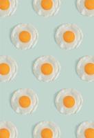 Flat lay pattern with poached eggs on a light mint green background. Minimal concept food concept. Trendy mockup or a wallpaper. photo