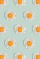 Flat lay pattern with poached eggs on a light mint green background. Minimal concept food concept. Trendy mockup or a wallpaper. photo