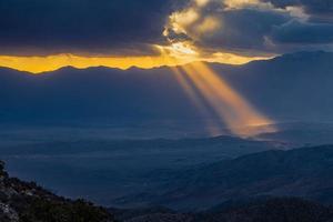 Image of a spectacular weather scene with impressive sun rays through a hole in the clouds photo