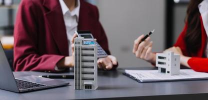 Discussion with a real estate agent, House model with agent and customer discussing for the contract to buy, get insurance or loan real estate or property. photo