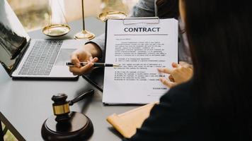 Male lawyer working with contract papers and wooden gavel on tabel in courtroom. justice and law ,attorney, court judge, concept. photo