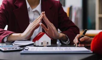 Discussion with a real estate agent, House model with agent and customer discussing for the contract to buy, get insurance or loan real estate or property. photo