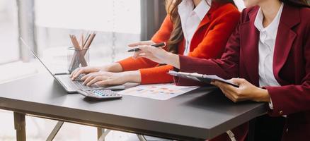 hombre de negocios y equipo analizando la tarea financiera de los estados financieros. con teléfono inteligente y computadora portátil y tableta. concepto de gestión de riqueza foto