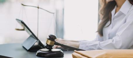 Male lawyer working with contract papers and wooden gavel on tabel in courtroom. justice and law ,attorney, court judge, concept. photo