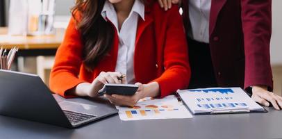 hombre de negocios y equipo analizando la tarea financiera de los estados financieros. con teléfono inteligente y computadora portátil y tableta. concepto de gestión de riqueza foto