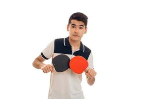 young brunette man playing ping-pong isolated on white background in studio photo