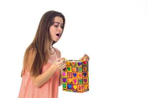 young girl looks at color package and wonders is isolated on  white background photo