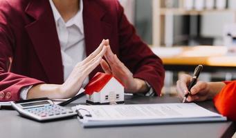 Discussion with a real estate agent, House model with agent and customer discussing for the contract to buy, get insurance or loan real estate or property. photo