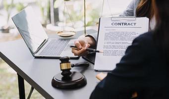 abogado masculino que trabaja con papeles de contrato y mazo de madera en tabel en la sala del tribunal. justicia y derecho, abogado, juez de la corte, concepto. foto