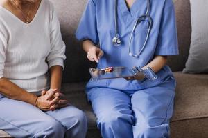 Homecare nursing service and elderly people cardiology healthcare. Close up of young hispanic female doctor nurse check mature caucasian man patient heartbeat using stethoscope during visit photo