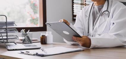 Homecare nursing service and elderly people cardiology healthcare. Close up of young hispanic female doctor nurse check mature caucasian man patient heartbeat using stethoscope during visit photo