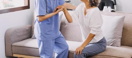 Homecare nursing service and elderly people cardiology healthcare. Close up of young hispanic female doctor nurse check mature caucasian man patient heartbeat using stethoscope during visit photo