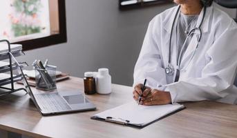 Homecare nursing service and elderly people cardiology healthcare. Close up of young hispanic female doctor nurse check mature caucasian man patient heartbeat using stethoscope during visit photo