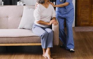 Homecare nursing service and elderly people cardiology healthcare. Close up of young hispanic female doctor nurse check mature caucasian man patient heartbeat using stethoscope during visit photo