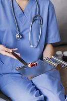 Homecare nursing service and elderly people cardiology healthcare. Close up of young hispanic female doctor nurse check mature caucasian man patient heartbeat using stethoscope during visit photo