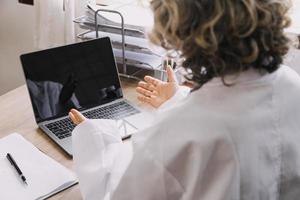 Homecare nursing service and elderly people cardiology healthcare. Close up of young hispanic female doctor nurse check mature caucasian man patient heartbeat using stethoscope during visit photo