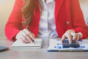 marketing, finanzas, contabilidad, planificación, negocios, las mujeres usan calculadoras y tabletas portátiles de computadora de análisis gráfico para planificar estrategias de marketing y hacer inversiones rentables para la empresa. foto