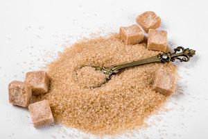 A pile of granulated cane sugar and pieces photo
