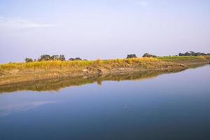 Arial View Canal with green grass and vegetation reflected in the water nearby Padma river in Bangladesh photo