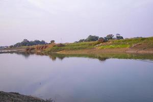 Arial View Canal with green grass and vegetation reflected in the water nearby Padma river in Bangladesh photo