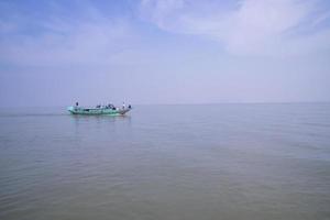 barco de viaje tradicional aginest blue sky en el río padma - bangladesh foto