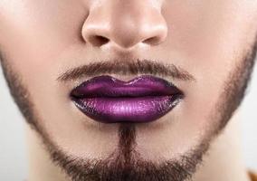 Macro photo of bearded male lips with makeup
