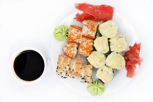 Delicious baked sushi and rolls on a white plate. Delicious breakfast of fish rice rolls and sushi on a white background. Oriental fish cuisine. Japanese cuisine. photo